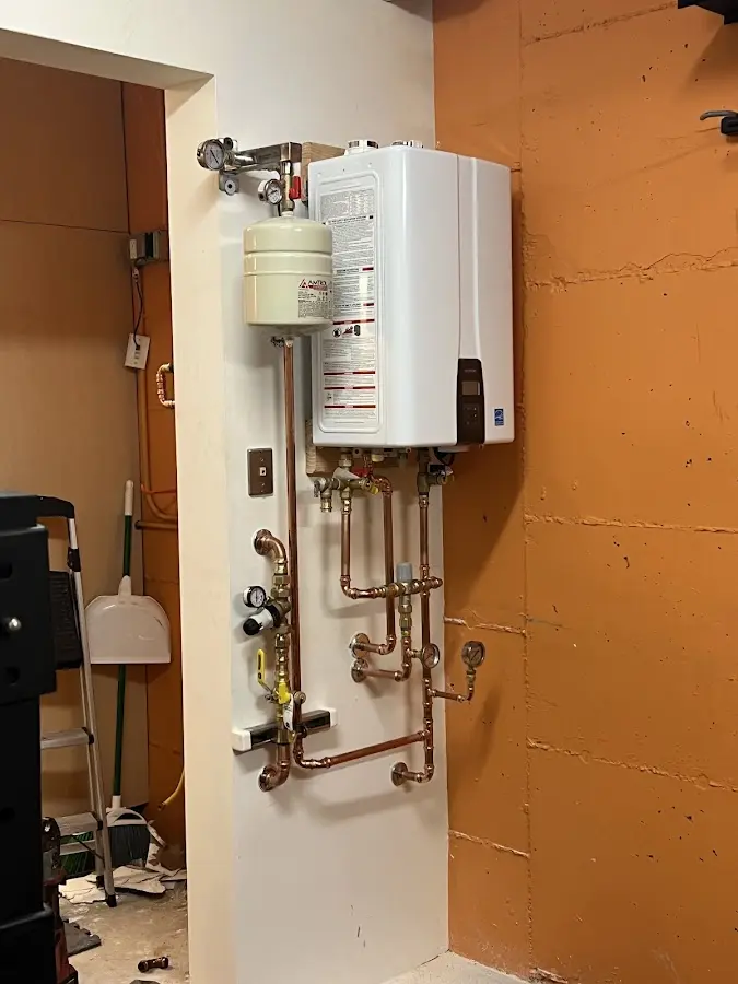 Plumbing technician inspecting water heater connections in Farmersville